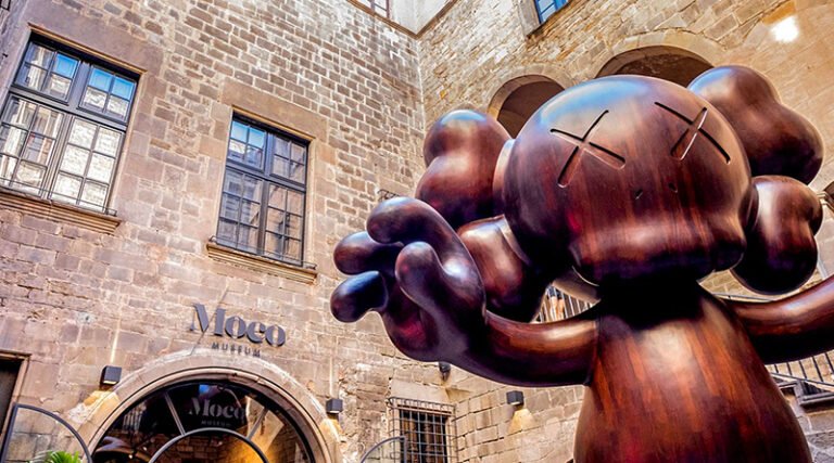Outdoor courtyard area of the Moco Museum Barcelona with modern art installations and visitors walking through the space