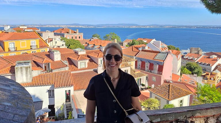 Traveler standing on the walls of São Jorge Castle overlooking panoramic views of Lisbon
