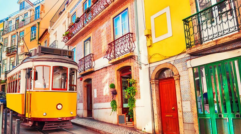 Yellow historic tram moving through the streets of Lisbon with panoramic city views in the background