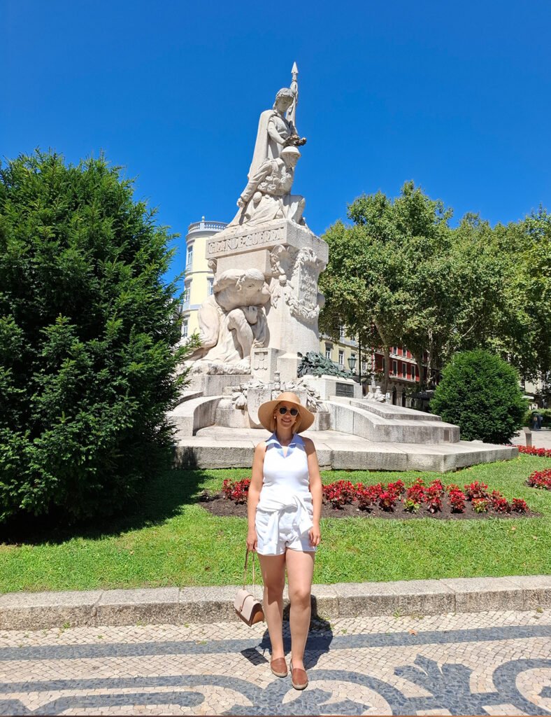 Traveler standing in front of a public sculpture in Lisbon in an urban square or cultural area