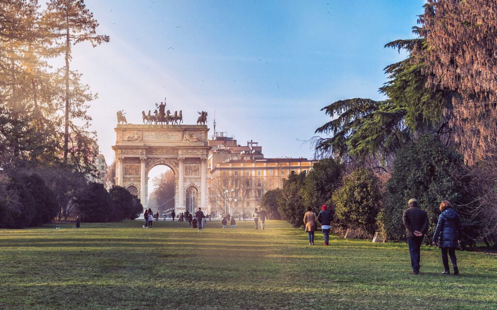 MILAN, ITALY Arco della Pace in Milan viewed from the surrounding park, framed by trees and green space.