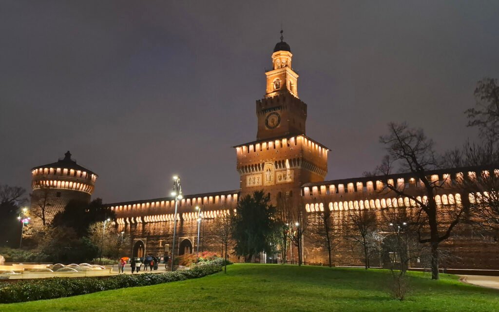 MILAN, ITALY Sforza Castle in Milan illuminated at night, showcasing the historic fortress and its architectural details.