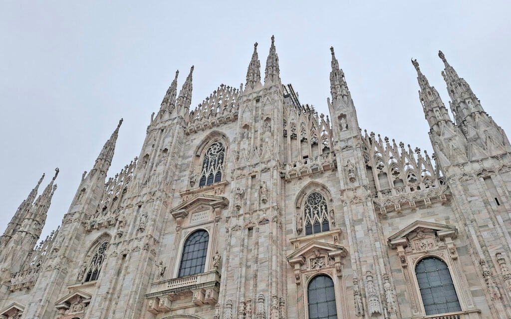 MILAN, ITALY Frontal view of Duomo di Milano in Milan, showcasing its Gothic facade with spires, statues, and ornate details.