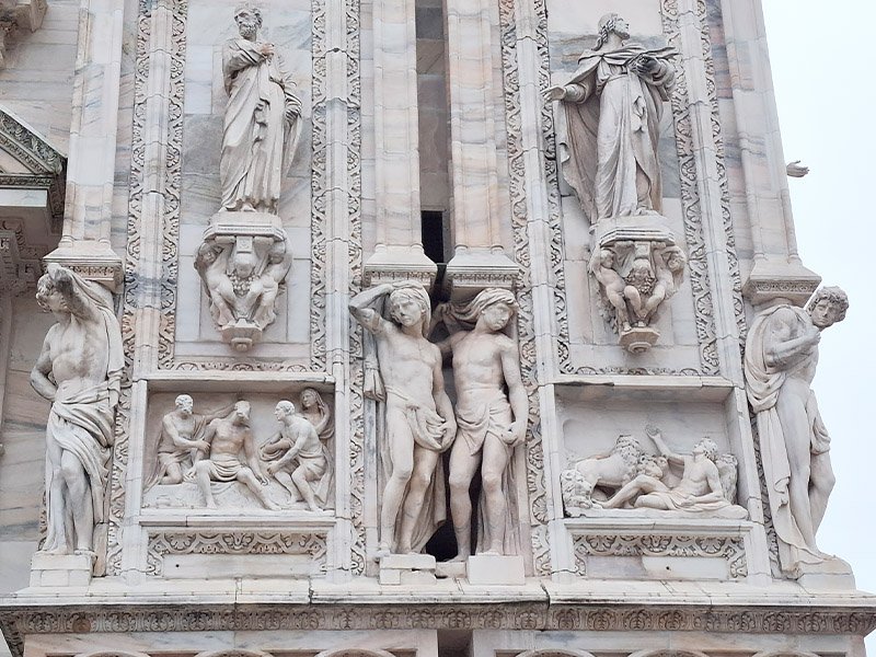 Sculptures carved into the walls of Duomo di Milano, showcasing Gothic artistry and intricate stonework.